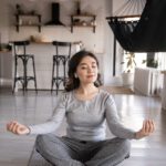 Eine Frau auf einer yoga Matte die meditiert
